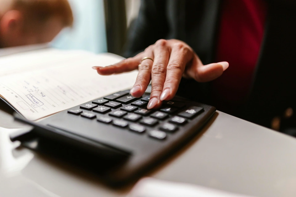 Close-up of hands using a calculator for budgeting