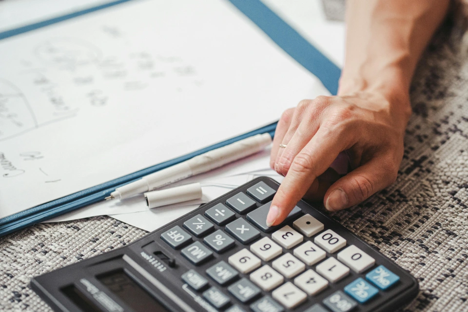 Person using a calculator for budgeting and planning.